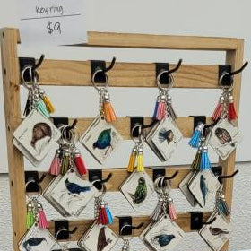 Display of art prints and cards on a table with a sign in the background