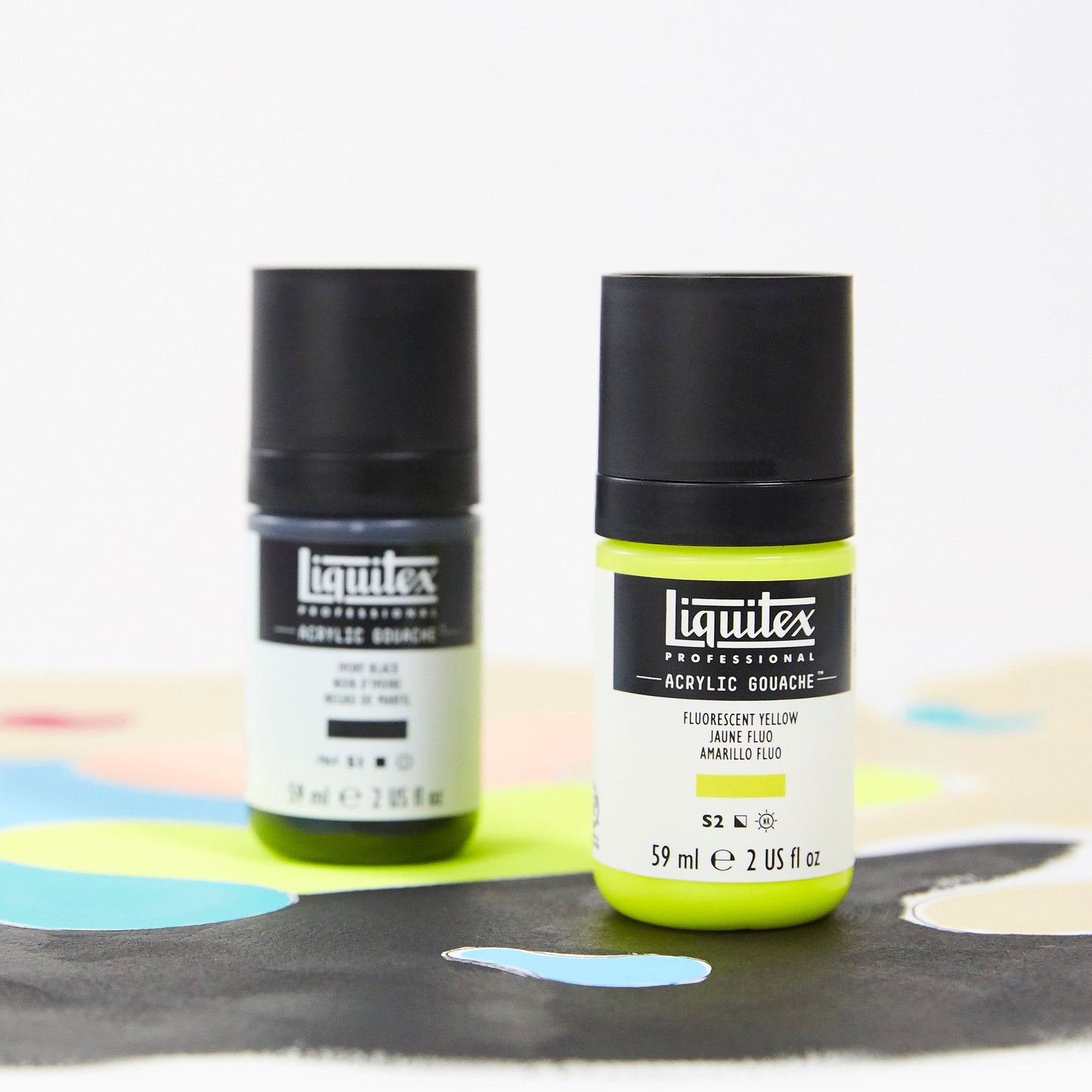 Two bottles of Liquitex spray paint on a white background with colorful paint splashes.