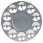 A round silver metal makeup palette with ten circular wells arranged in a ring around a central well, shown on a plain white background.