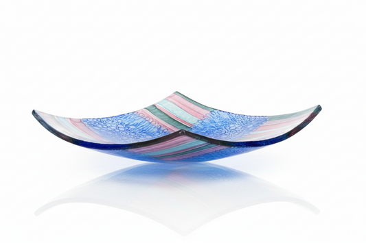 Colorful glass bowl with blue and pink stripes on a white background by glass artist David Traub