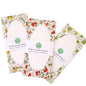 Three floral-patterned notebooks on a blue wooden surface