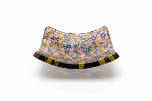 Decorative glass bowl with multicolored pattern on a white background by glass artist David Traub